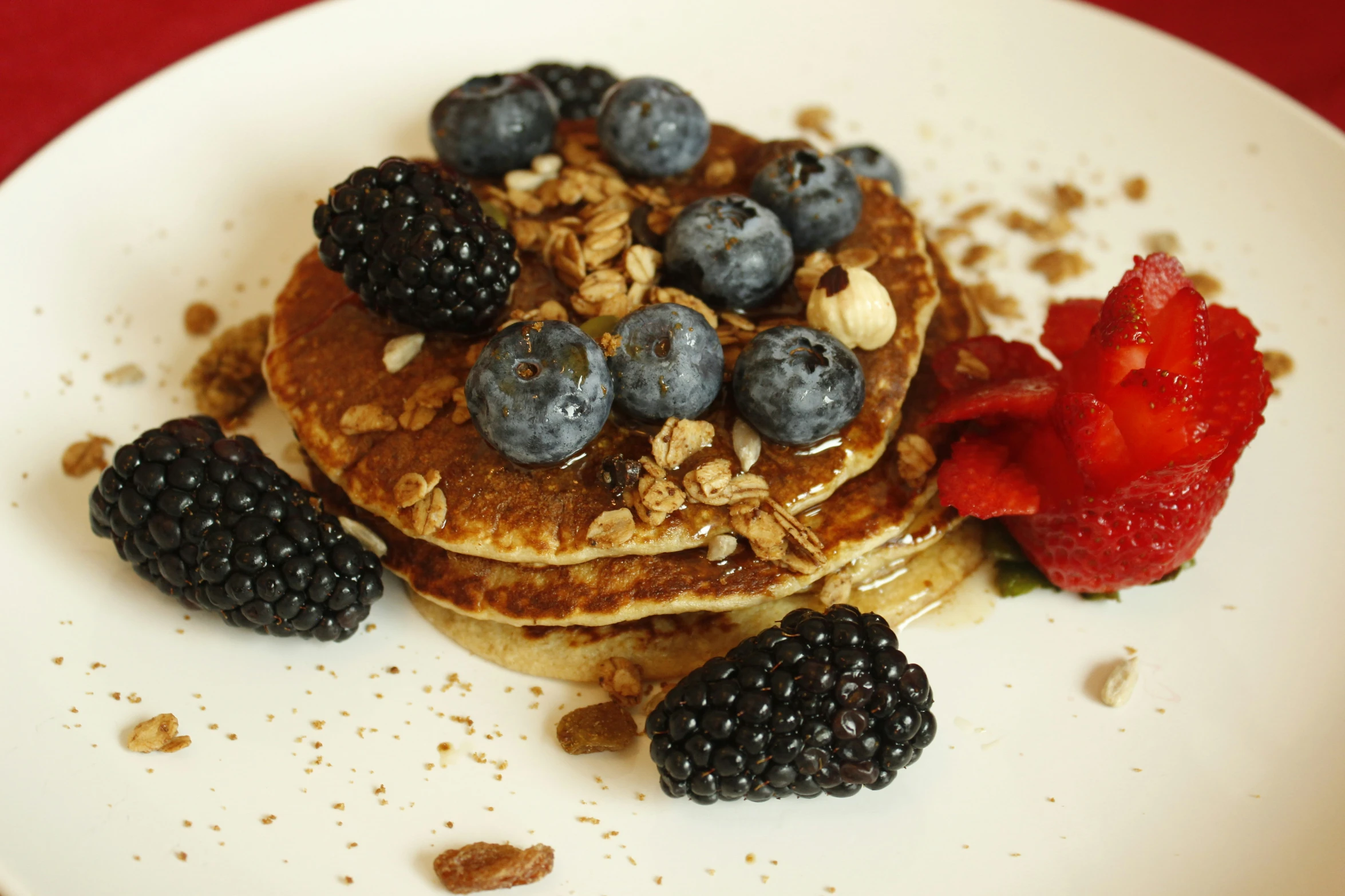 pancakes with blueberries and strawberries are on the plate