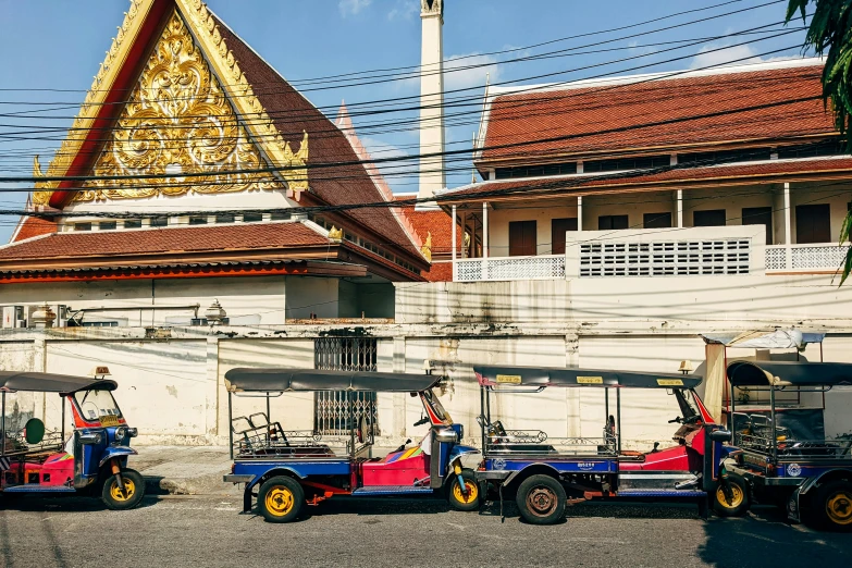 some cars parked on the side of a road with a building in the background