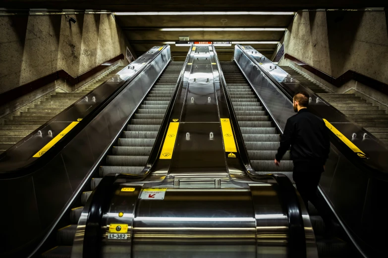 there is a man that is standing at the end of an escalator