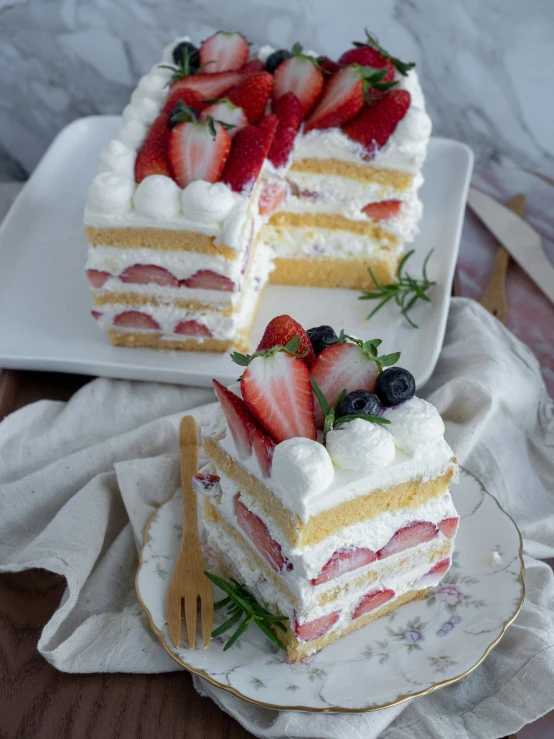 two slices of cake with strawberries and whipped cream on a plate