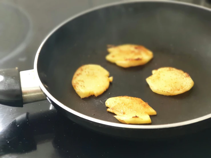 five pieces of food cooking in a frying pan