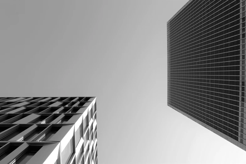 two buildings with black lines and a gray sky