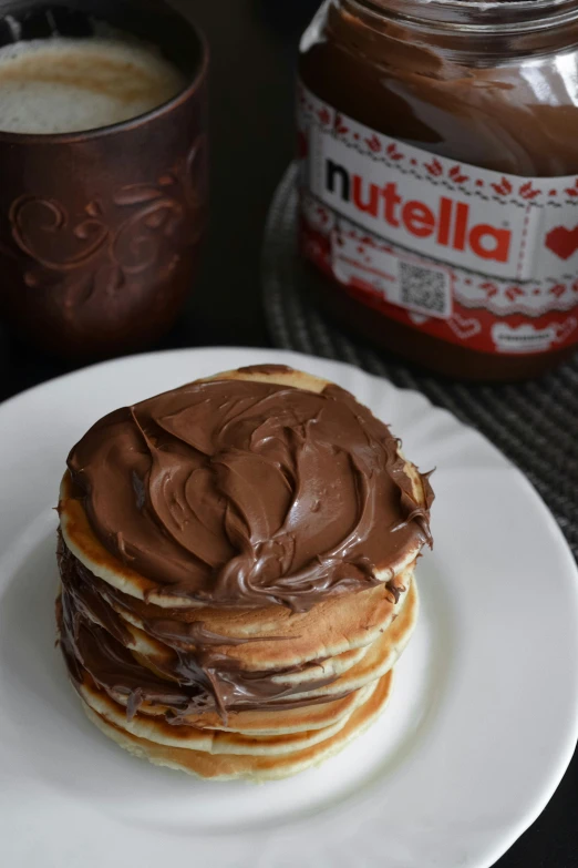 pancakes topped with chocolate and a cup of coffee