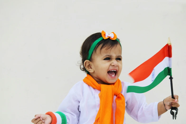 little indian girl holding india flag in white background