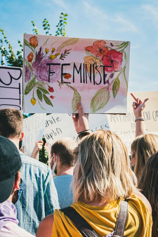 some people are holding signs that say feminist