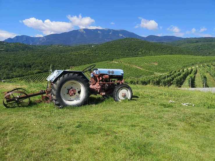 an old tractor on the side of a dirt road