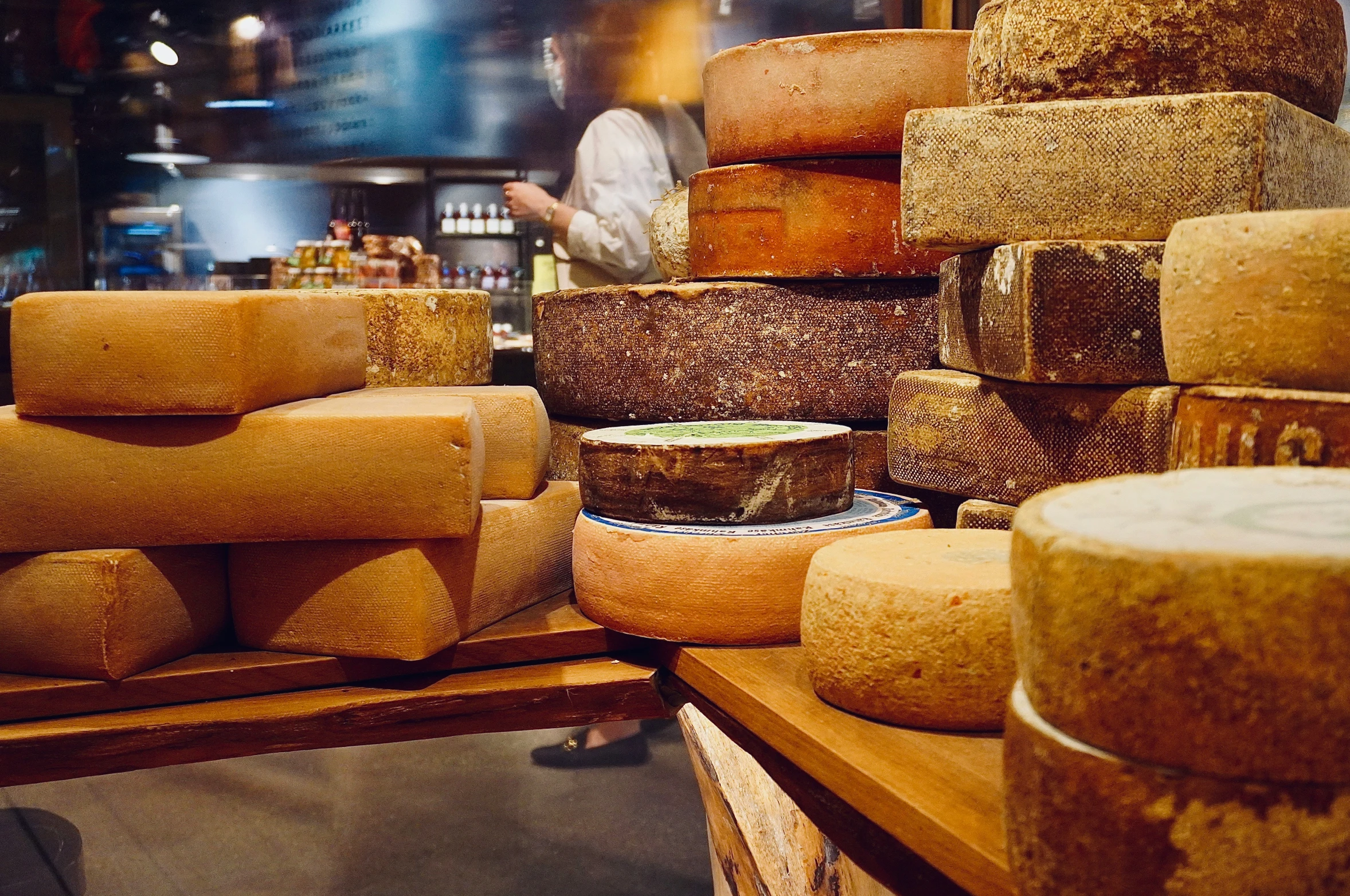 a person standing behind some wooden slices of cheese