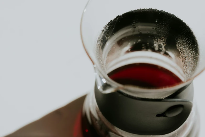 a glass cup with liquid sitting on top of a table