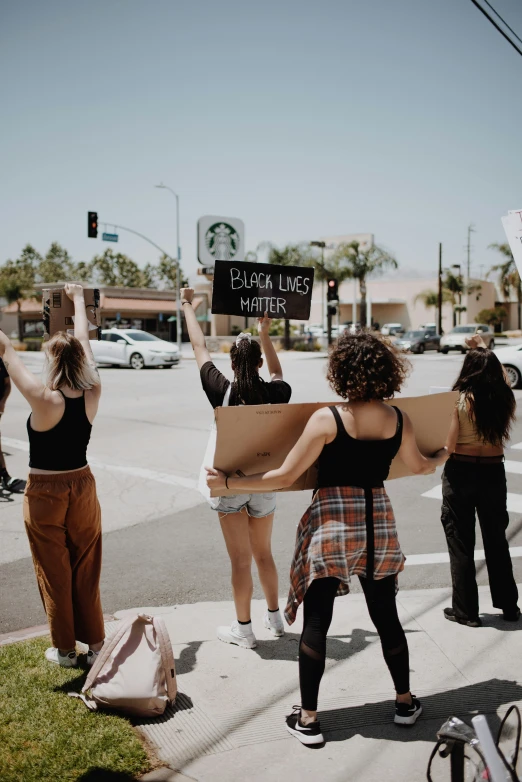 people holding signs up while on a street