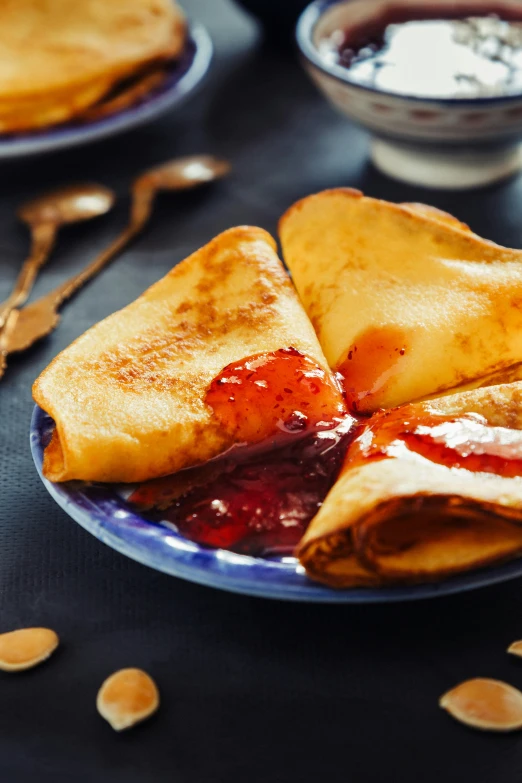 crepes filled with jam and sauce on a plate