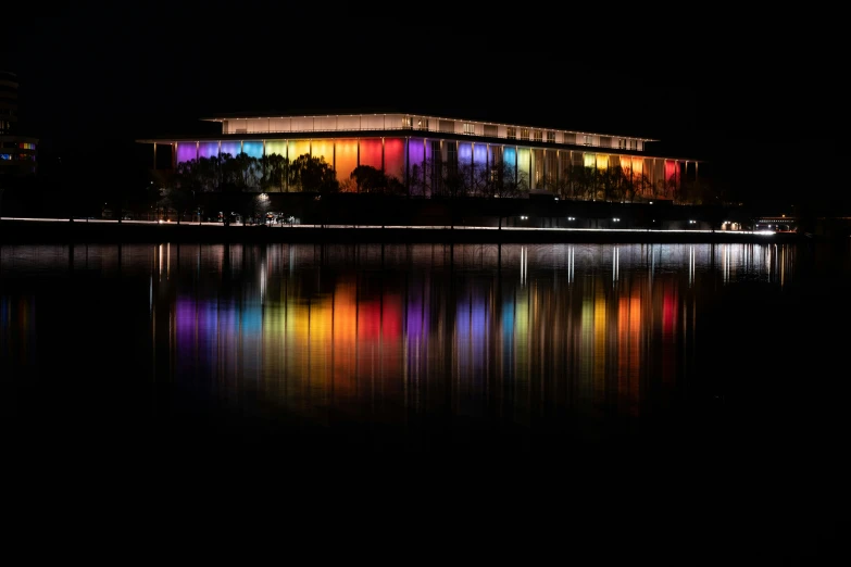 a colorful light filled building reflected in water