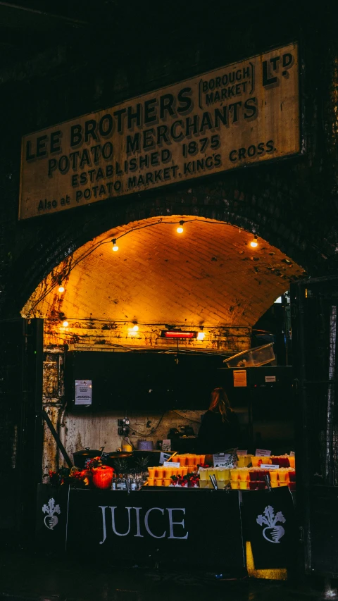 a fruit stand with lit up signs on it