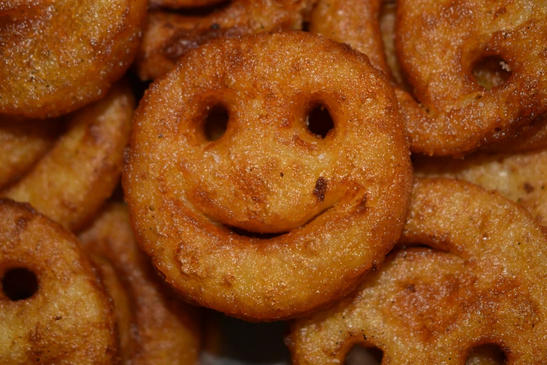 a smile - shaped doughnut sitting in front of some other doughnuts