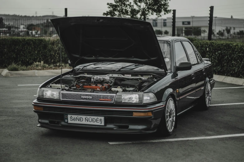 a car with its hood open in a parking lot