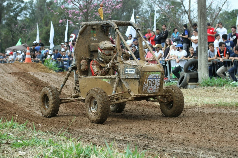 a group of men riding an off road buggy on a dirt course