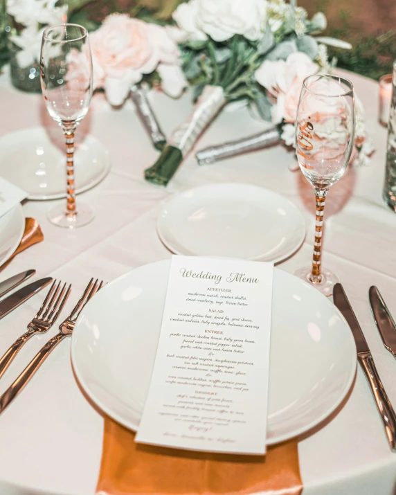 the table is decorated with silverware and roses