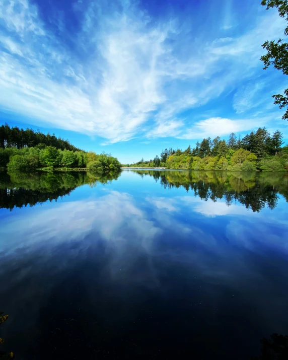 a river that is under blue skies with clouds