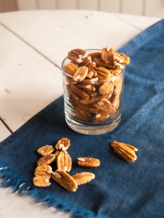 a glass filled with chopped pecans sitting on top of a table