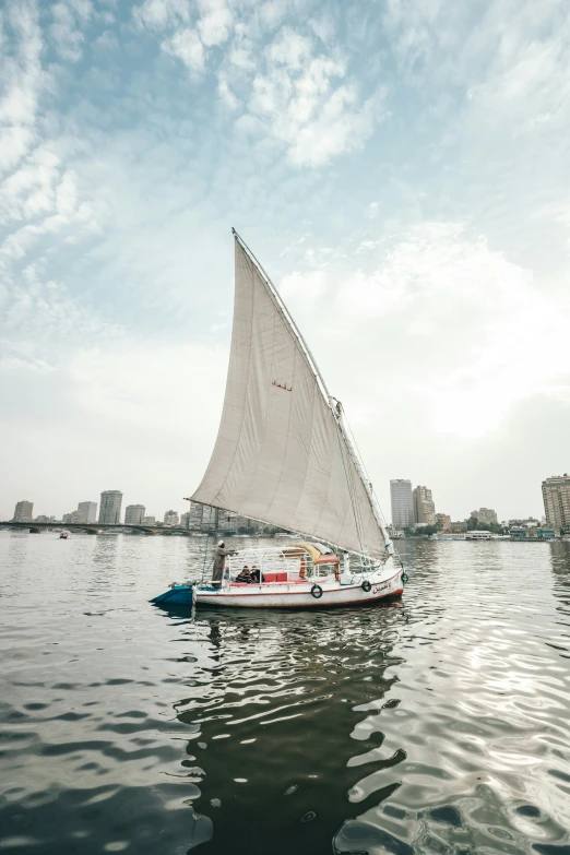 a sailboat with sails down sailing through the water