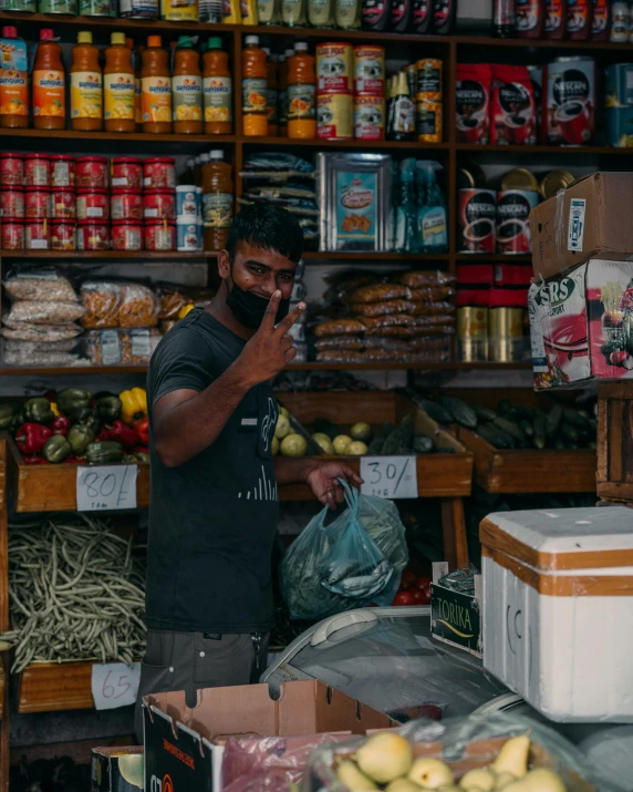 a man holding a cell phone next to shelves with food