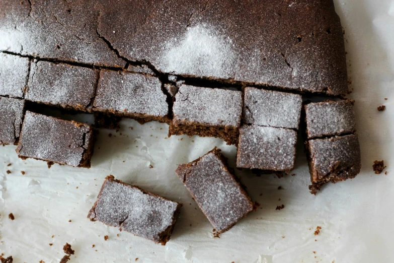 a sliced cake sits on some paper on a table