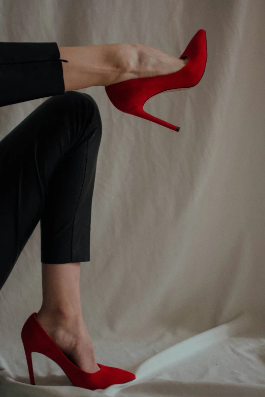 woman's legs with red shoes resting on the surface