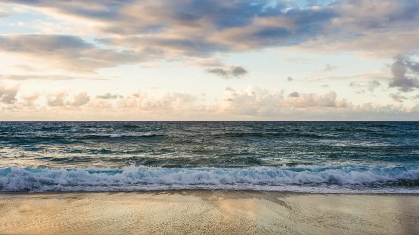 some blue water waves on the sand and the sky