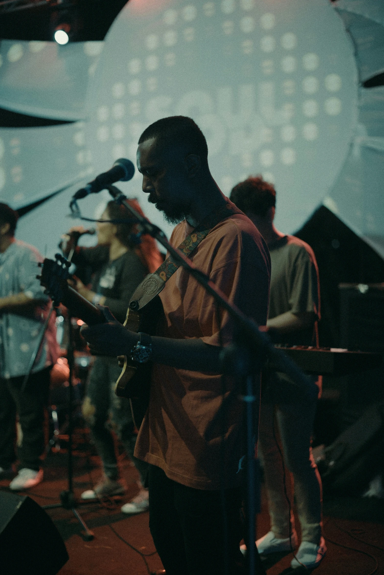 a man standing in front of a microphone while holding an instrument