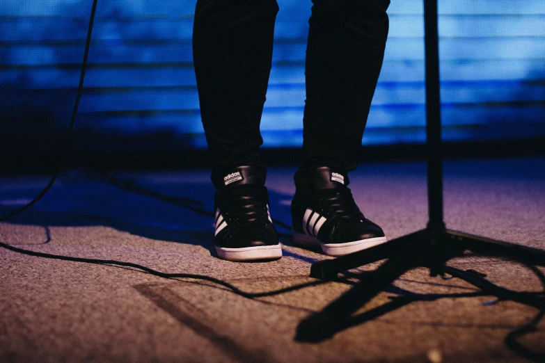 a man is standing on stage with his feet on the microphone