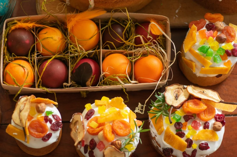 many eggs in baskets with oranges, orange slices and other colorful decorations