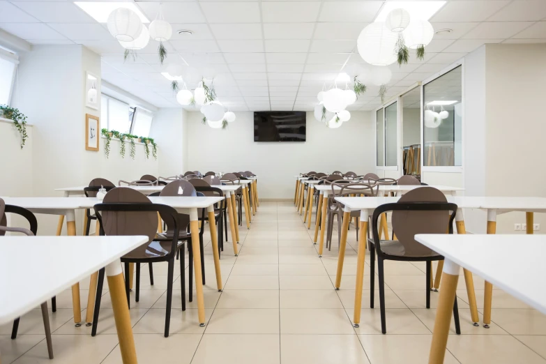 a classroom with tables, chairs and plants