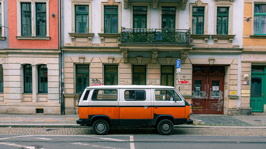 an orange and white van parked on the side of a road