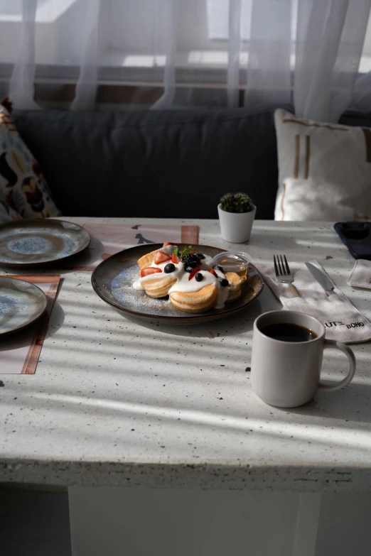 a white plate topped with pancakes next to a cup of coffee