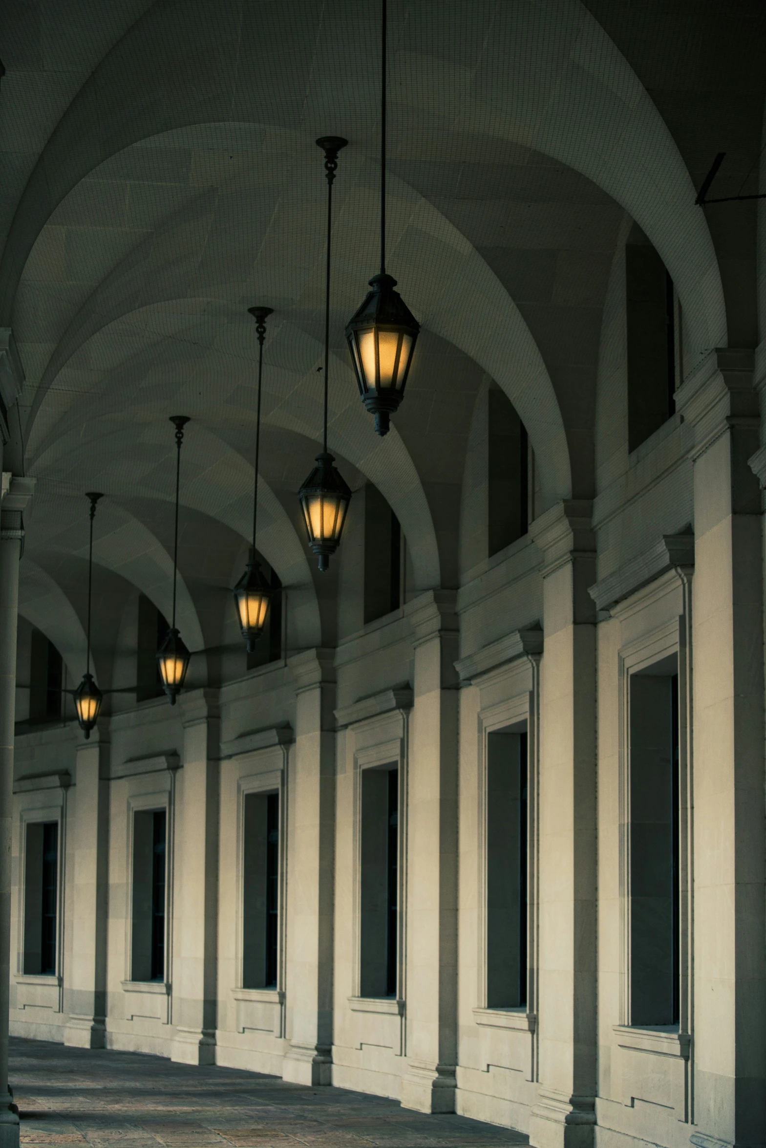 three lamps are hanging from the ceiling in a lobby