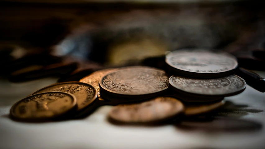 a pile of coins and two pairs of watch watches on a table