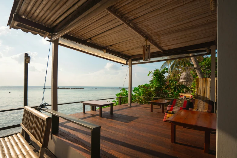 a wooden deck with chairs overlooks the ocean