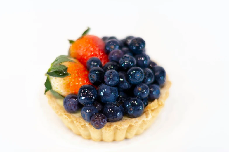 some blueberries and some oranges are sitting on some mini cookie