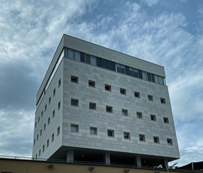 a very tall building with windows on a cloudy day