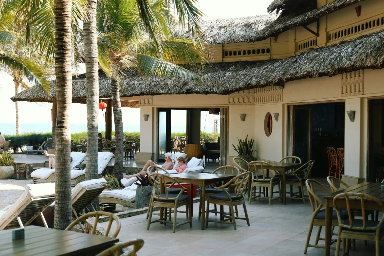 several people are eating at a table outside