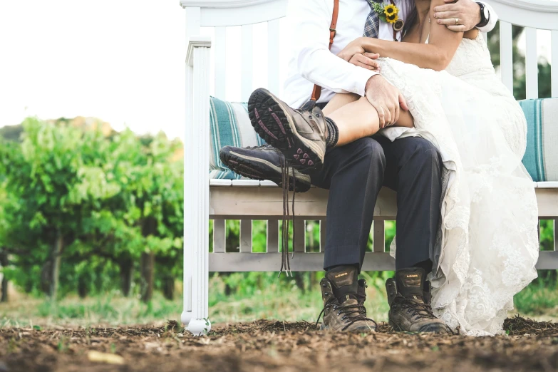 man sitting on bench hugging woman wearing boots