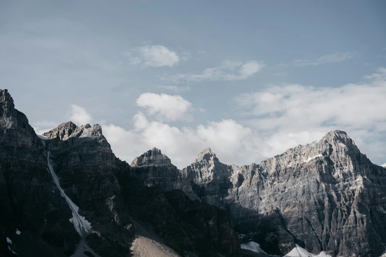 the mountains have snow on them and are partly covered by clouds