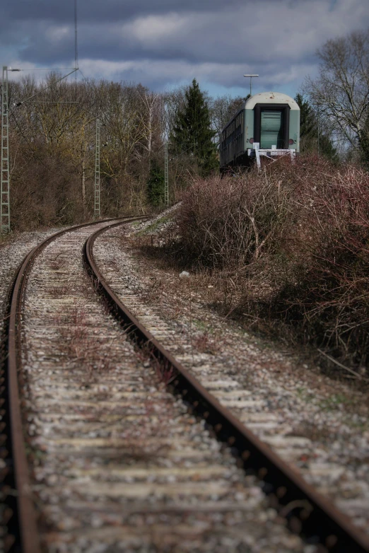 a train traveling along tracks through a lush green field