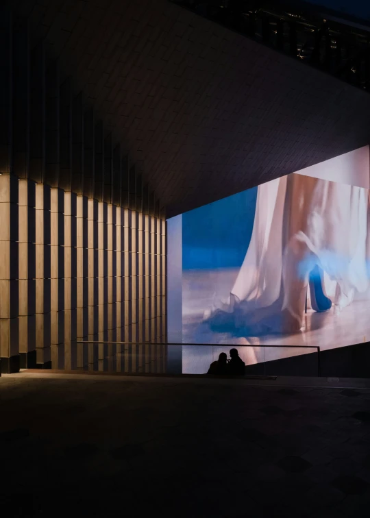 an image of a person sitting next to a building