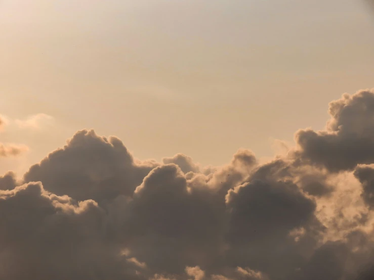 an airplane flying through the sky with clouds in the background