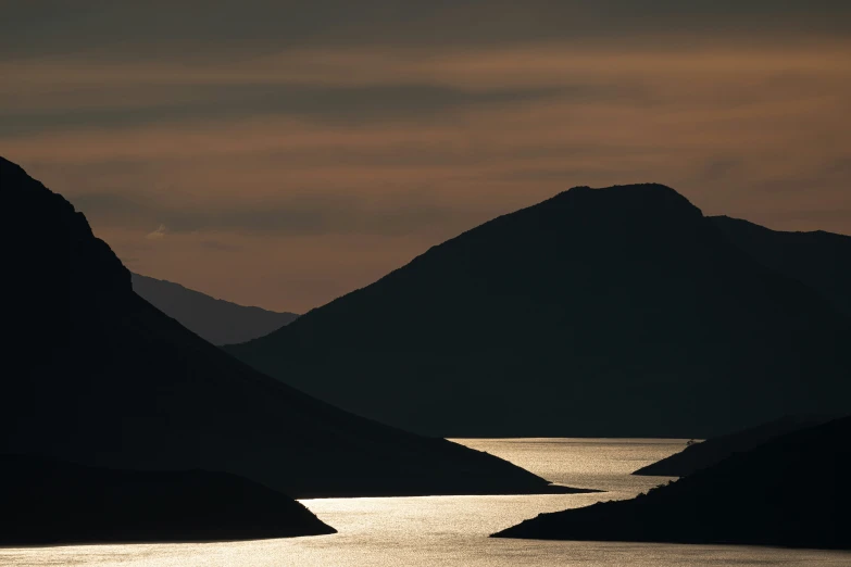 the view of the mountains surrounding the water from across the water