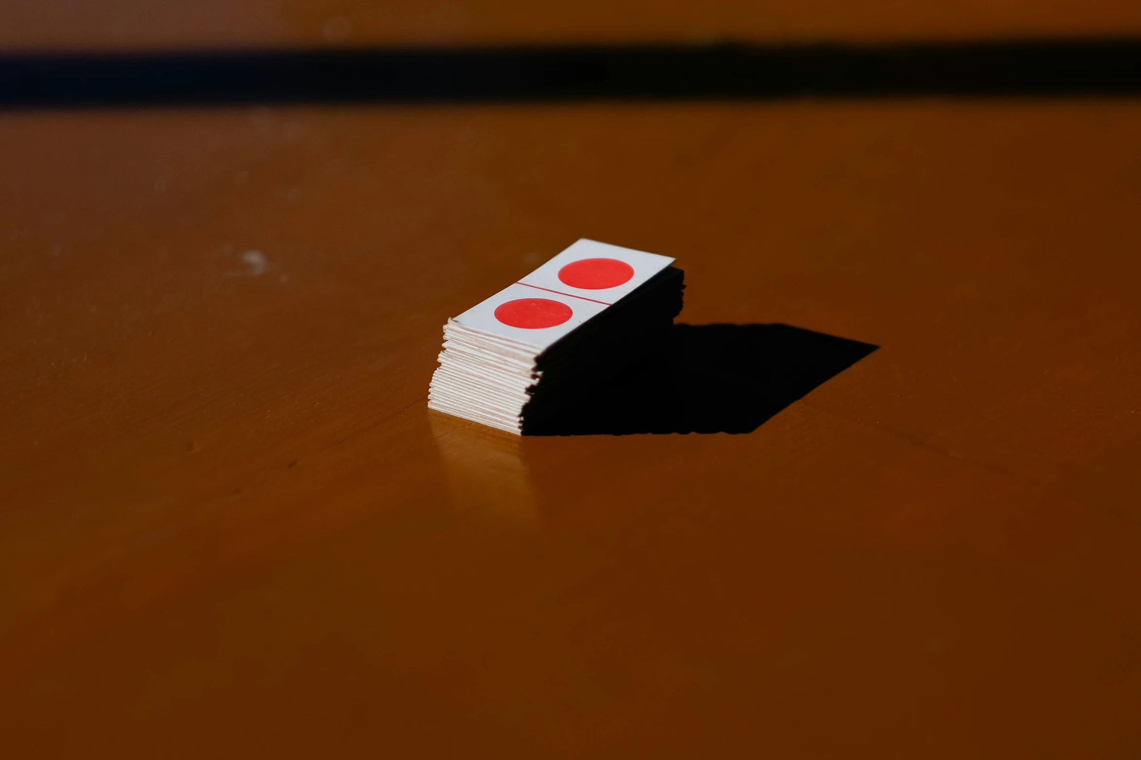 a stack of playing cards laying on top of a brown table