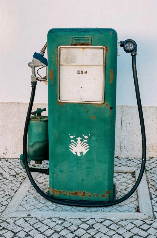 an old gas pump sitting in front of a wall