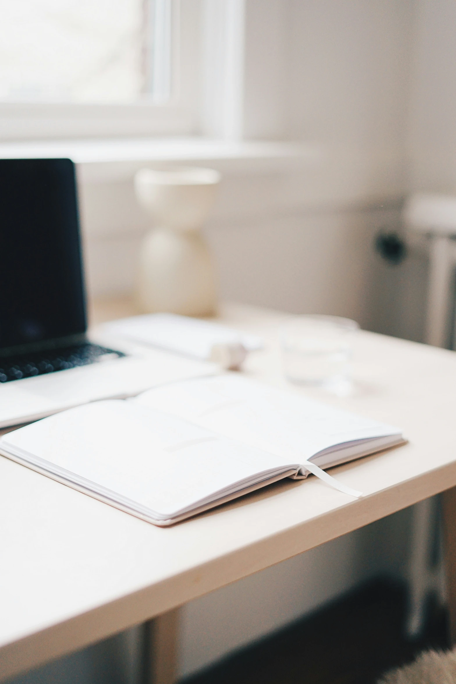 a desk with a laptop and a notebook on it