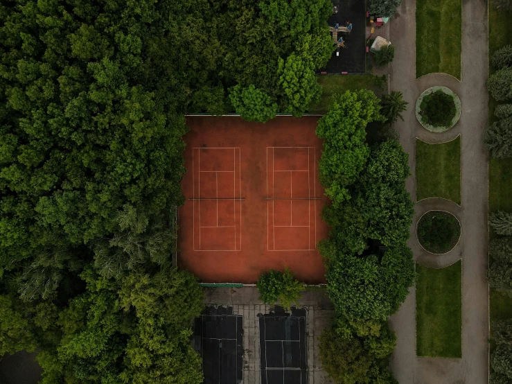 a tennis court surrounded by trees and grass