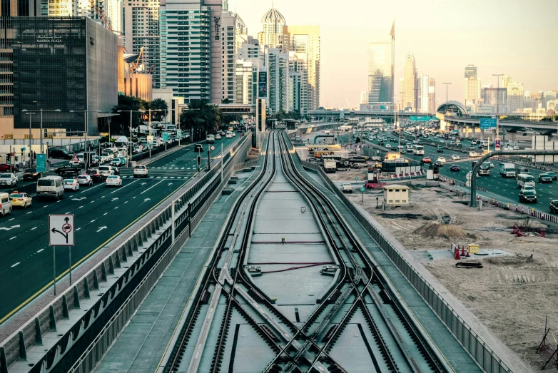 a road with lots of cars and a train tracks near a big city